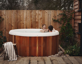 Couple in the hot tub at Malting Farm Cabins